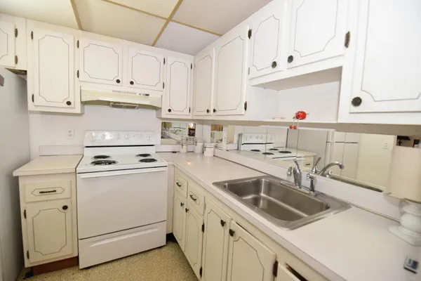 a kitchen with white cabinets sink and white appliances