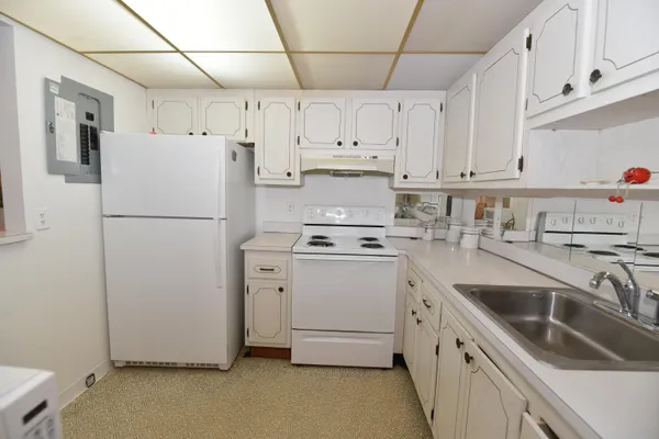 a kitchen with appliances a sink and cabinets