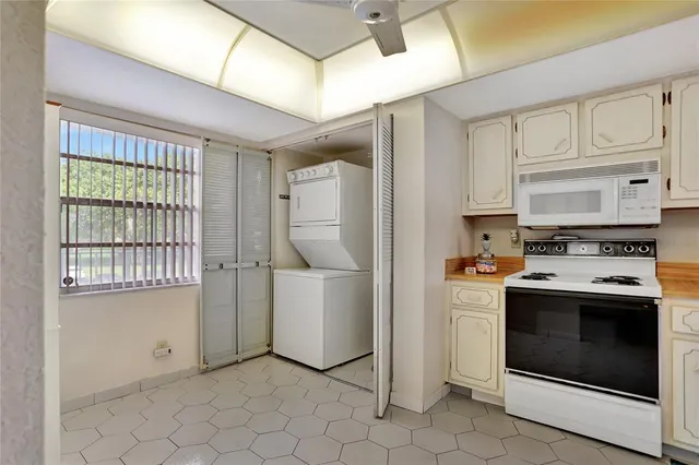 a kitchen with stainless steel appliances granite countertop a stove a refrigerator and a white cabinets