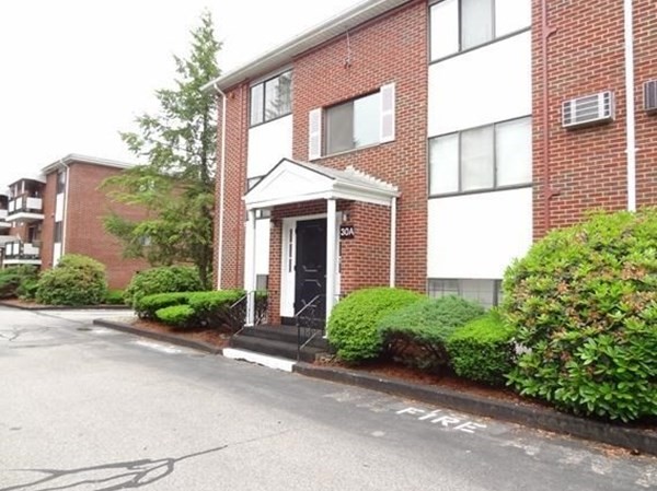 front view of a brick house with a yard