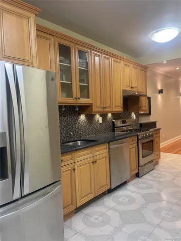 a kitchen with granite countertop a refrigerator and a sink