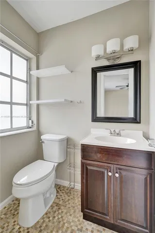 a bathroom with a toilet a sink and a window