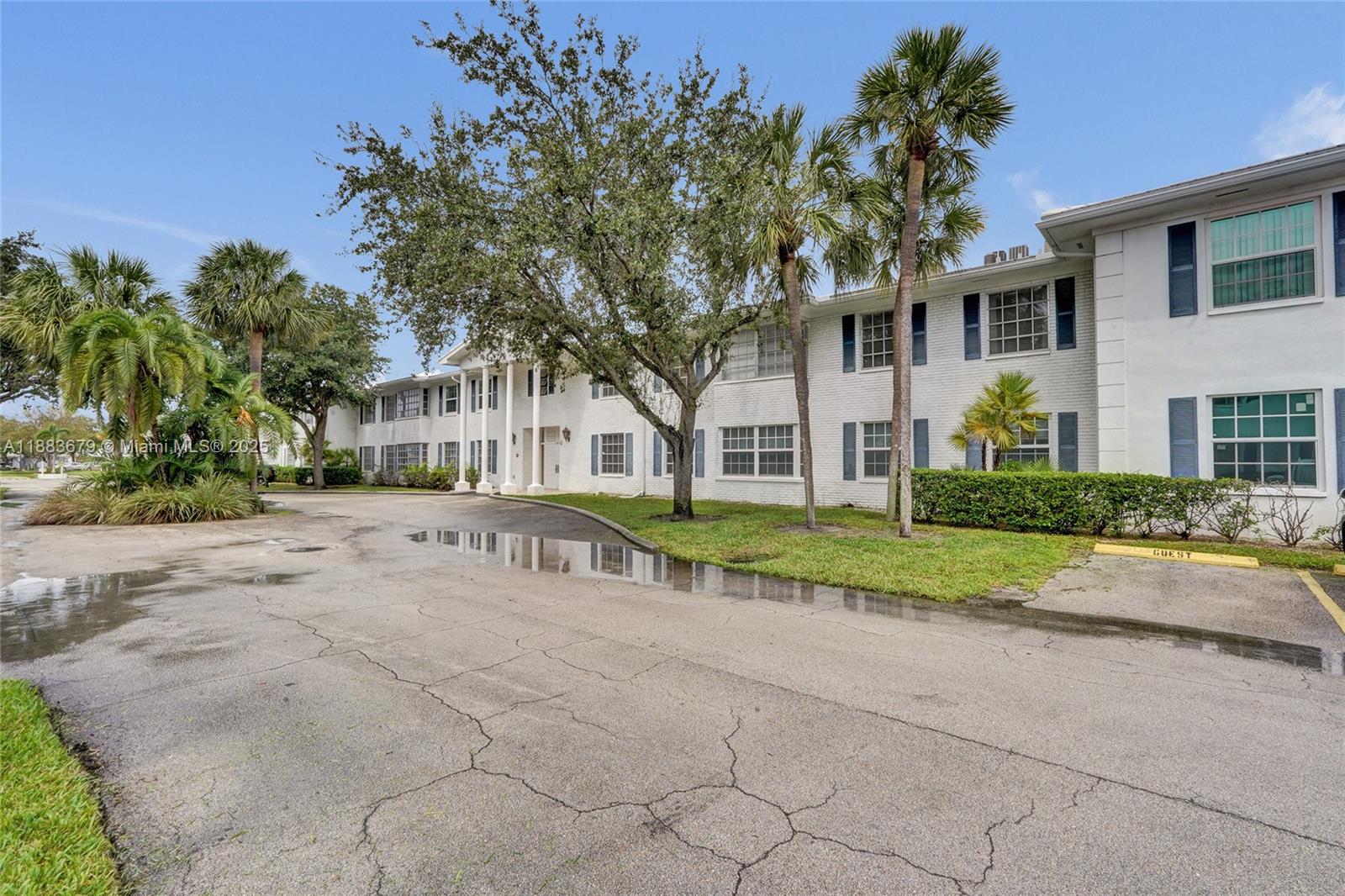 2181 Northeast 67th Street, Unit 622 Fort Lauderdale, FL 33308 - Photo 25 of 28 a view of a white house with a big yard and large trees