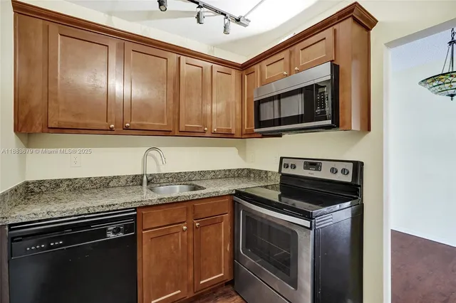 a kitchen with stainless steel appliances granite countertop a stove microwave and sink