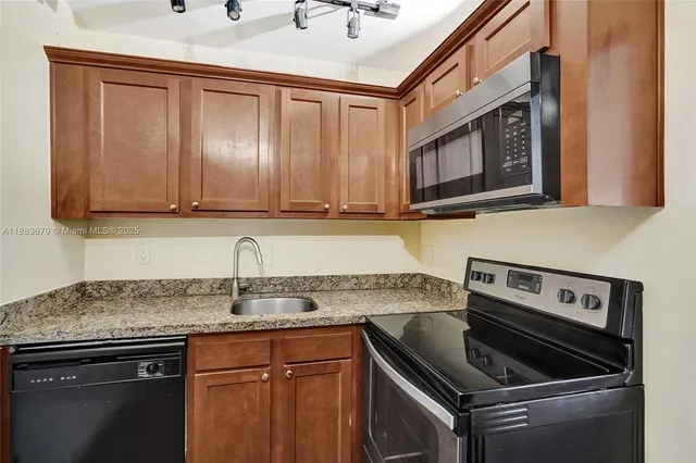 a kitchen with granite countertop a stove sink and cabinets