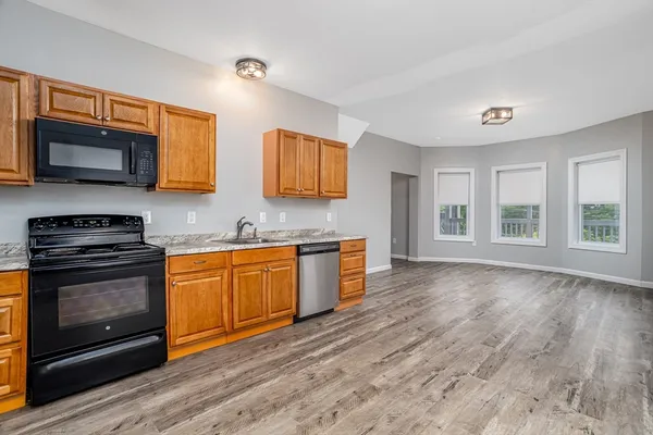 a kitchen with stainless steel appliances granite countertop a stove a sink and a microwave