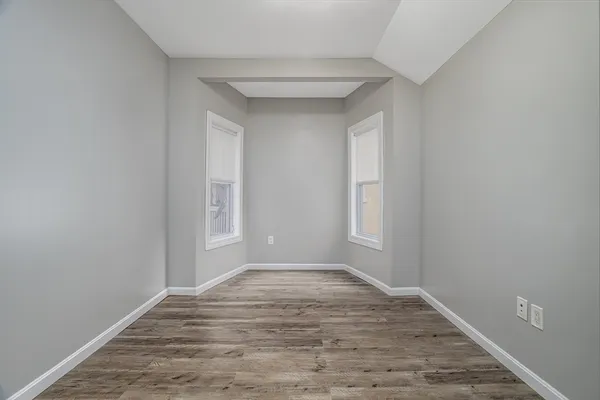 a view of empty room with wooden floor