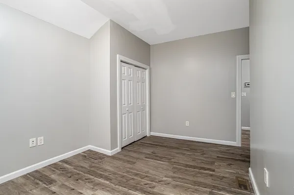 a view of an empty room with wooden floor