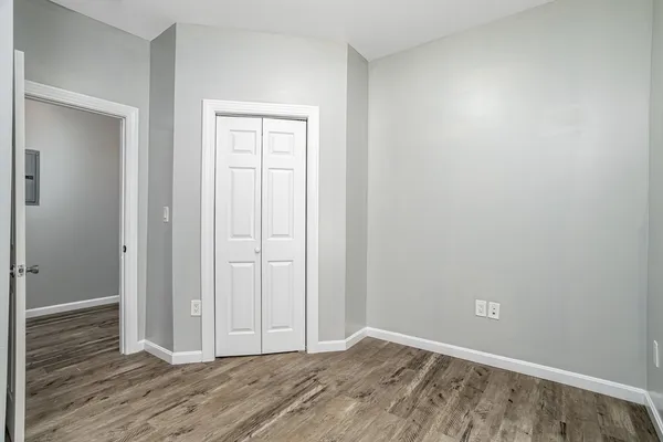 a view of an empty room with wooden floor