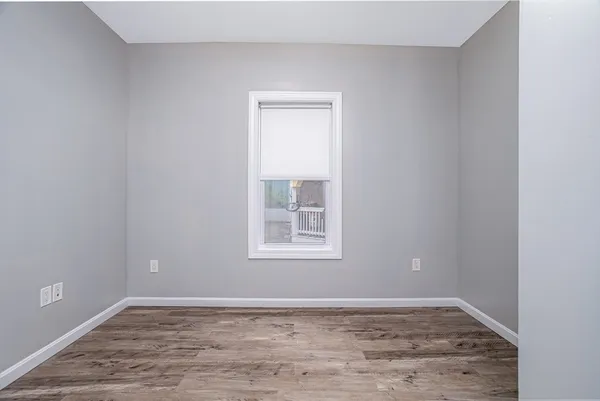a view of an empty room with closet and window