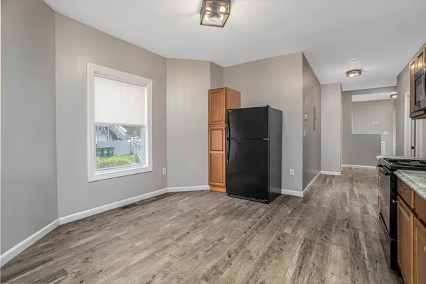 a view of empty room with wooden floor and window