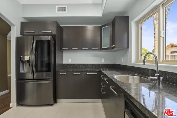 a kitchen with a sink and stainless steel appliances