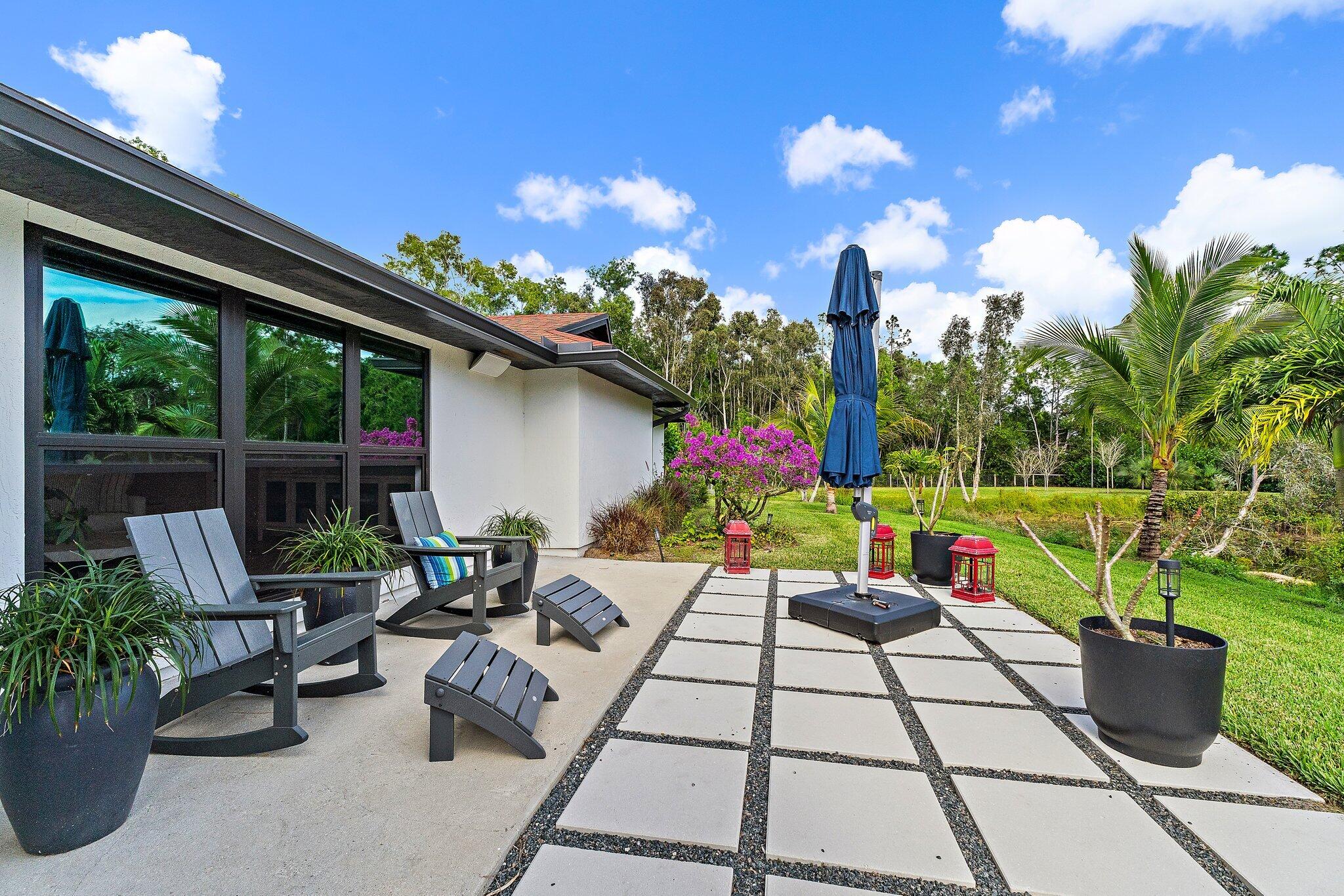 11845 165th Road North Jupiter, FL 33478 - Photo 13 of 68 a view of a patio with couches table and chairs and potted plants