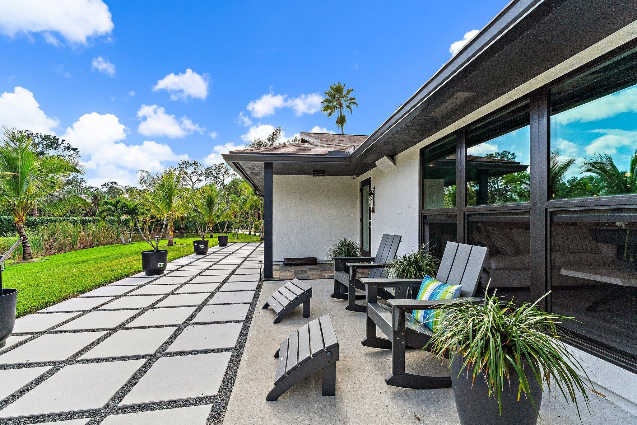 11845 165th Road North Jupiter, FL 33478 - Photo 14 of 68 a view of a patio with table and chairs potted plants with wooden fence