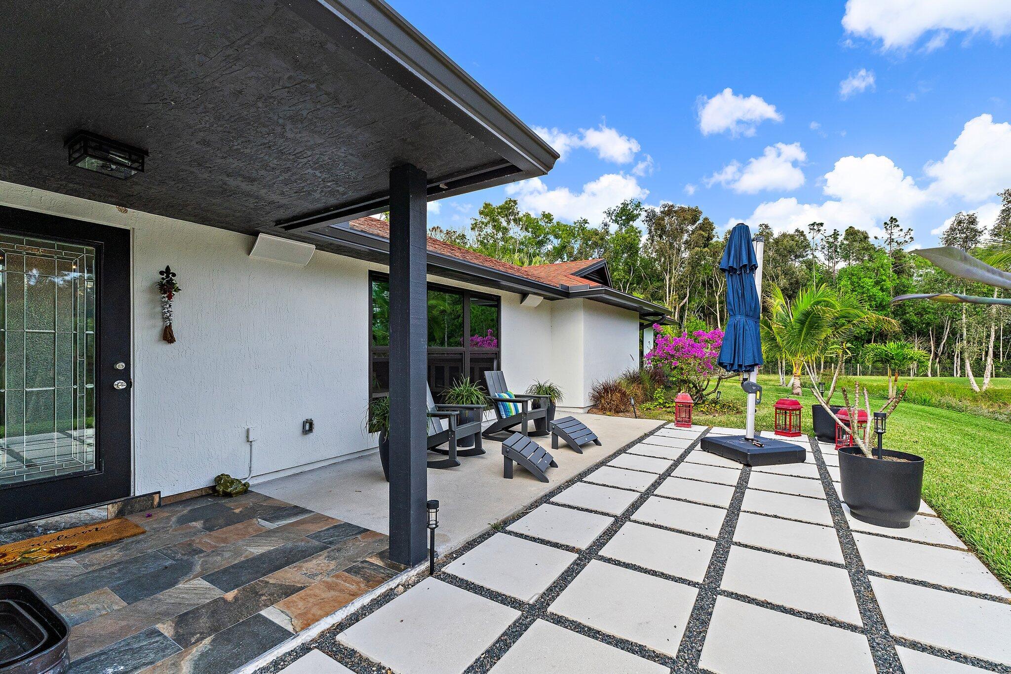 11845 165th Road North Jupiter, FL 33478 - Photo 15 of 68 a view of a patio with table and chairs and potted plants