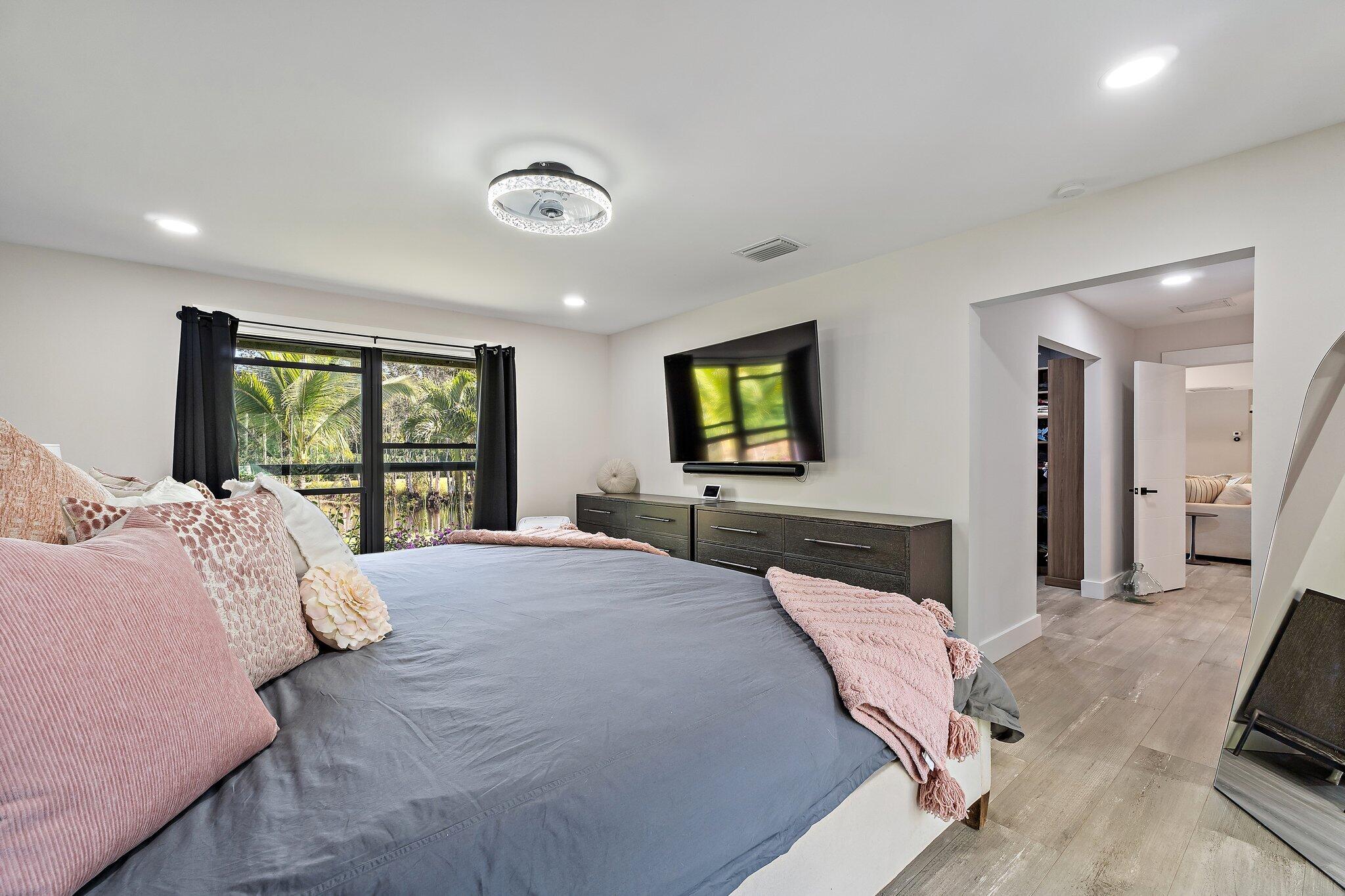 11845 165th Road North Jupiter, FL 33478 - Photo 39 of 68 a bedroom with a large bed and a flat screen tv