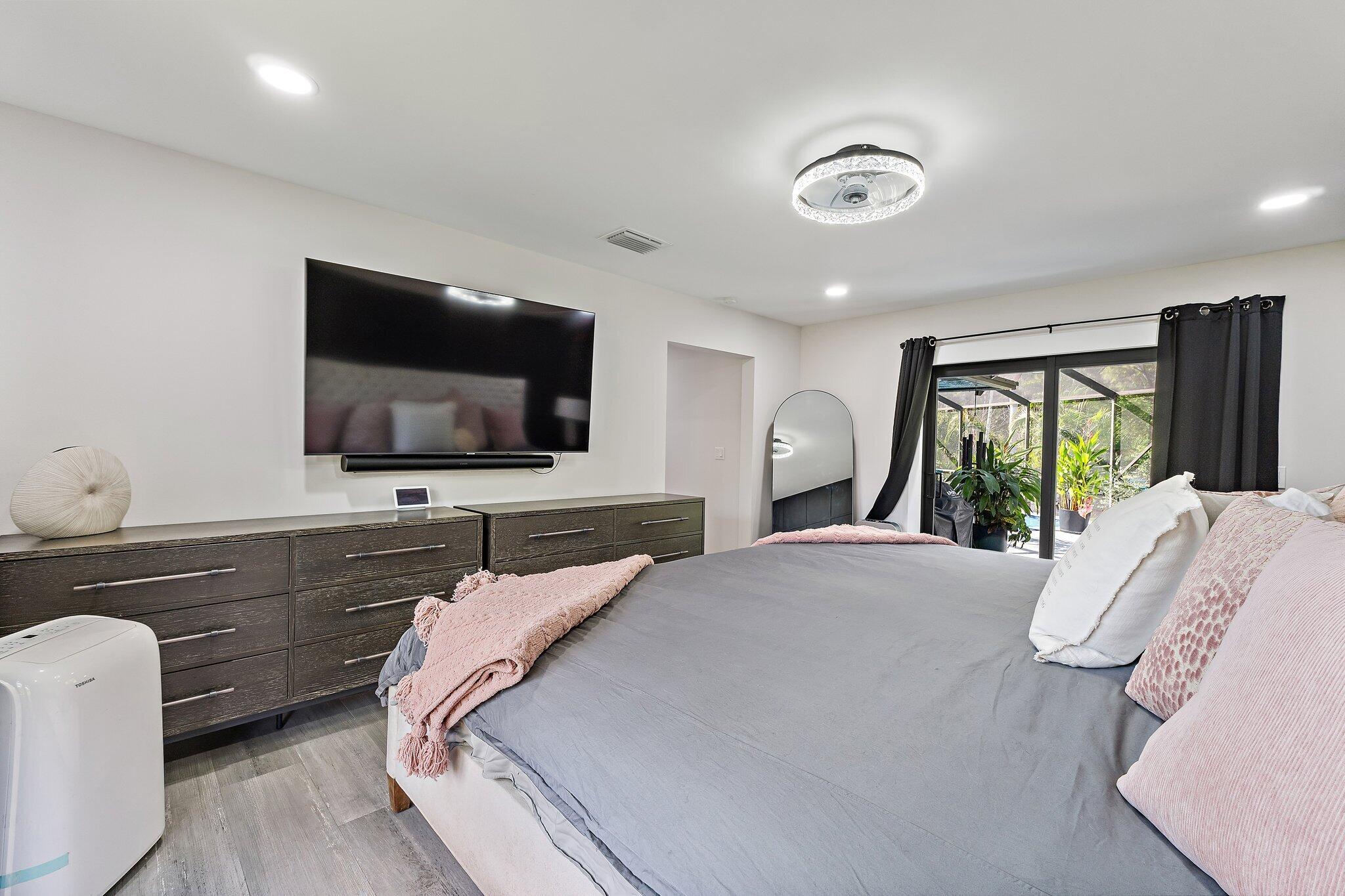 11845 165th Road North Jupiter, FL 33478 - Photo 40 of 68 a bedroom with a bed and a flat screen tv