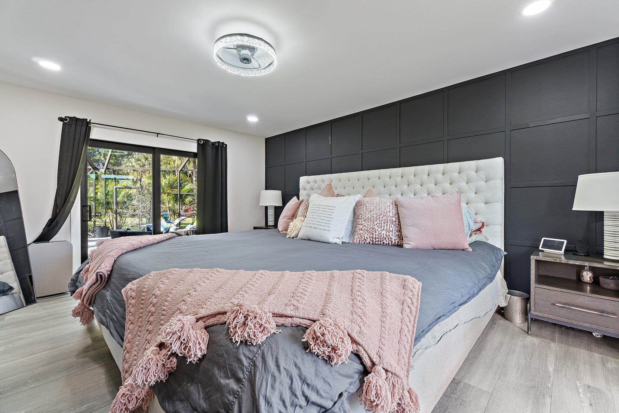 11845 165th Road North Jupiter, FL 33478 - Photo 41 of 68 a bed sitting in a bedroom next to a window