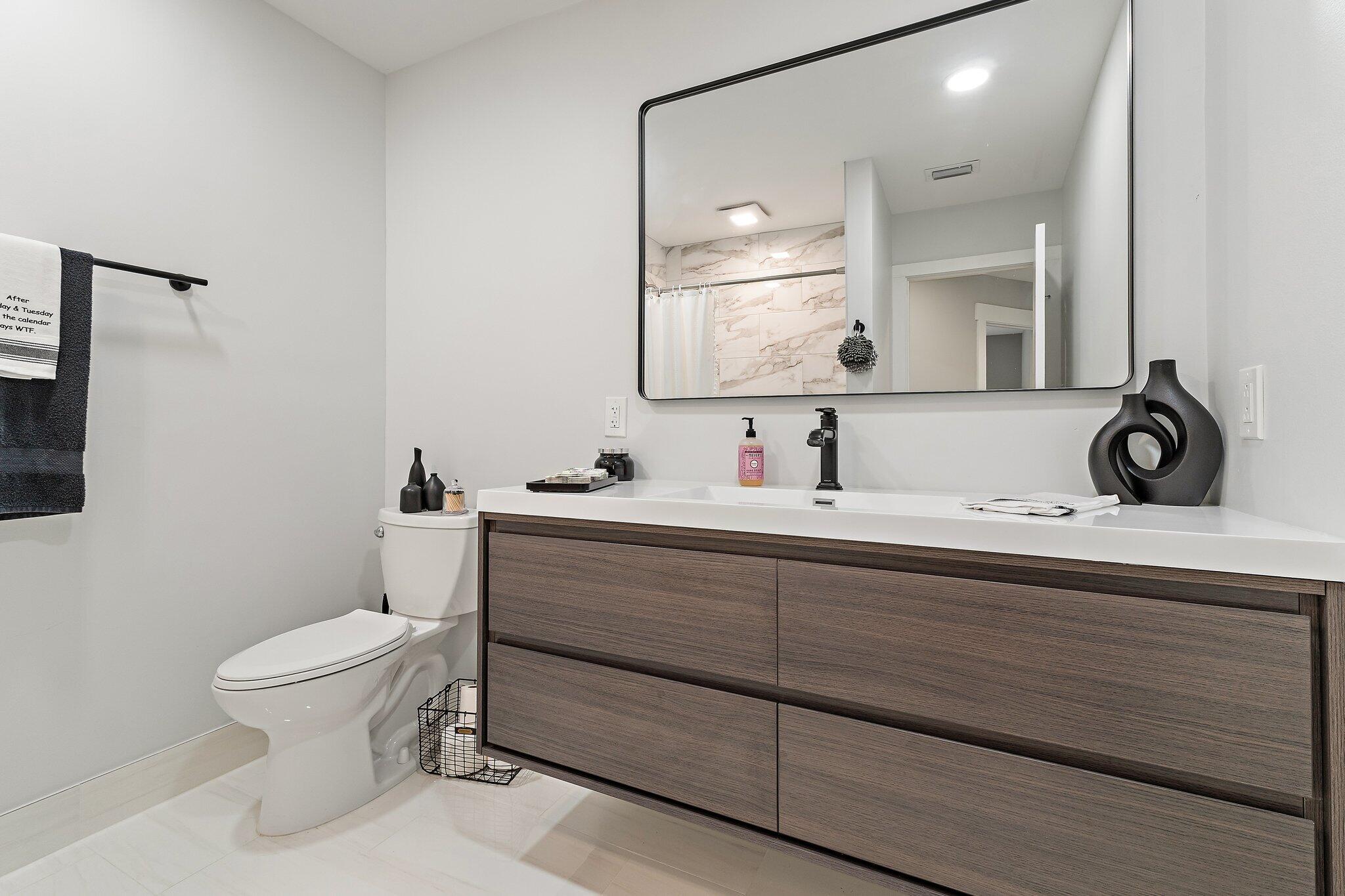 11845 165th Road North Jupiter, FL 33478 - Photo 42 of 68 a bathroom with a toilet a sink and mirror