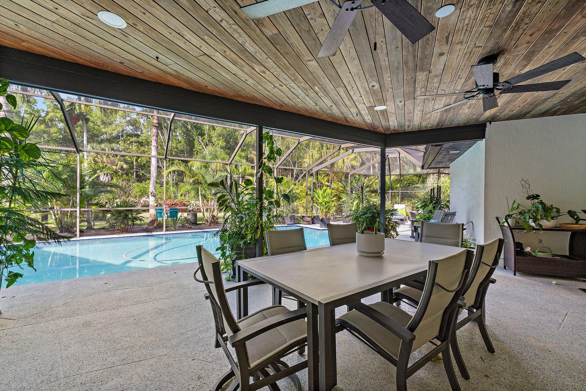 11845 165th Road North Jupiter, FL 33478 - Photo 51 of 68 a patio with table and chairs and potted plants
