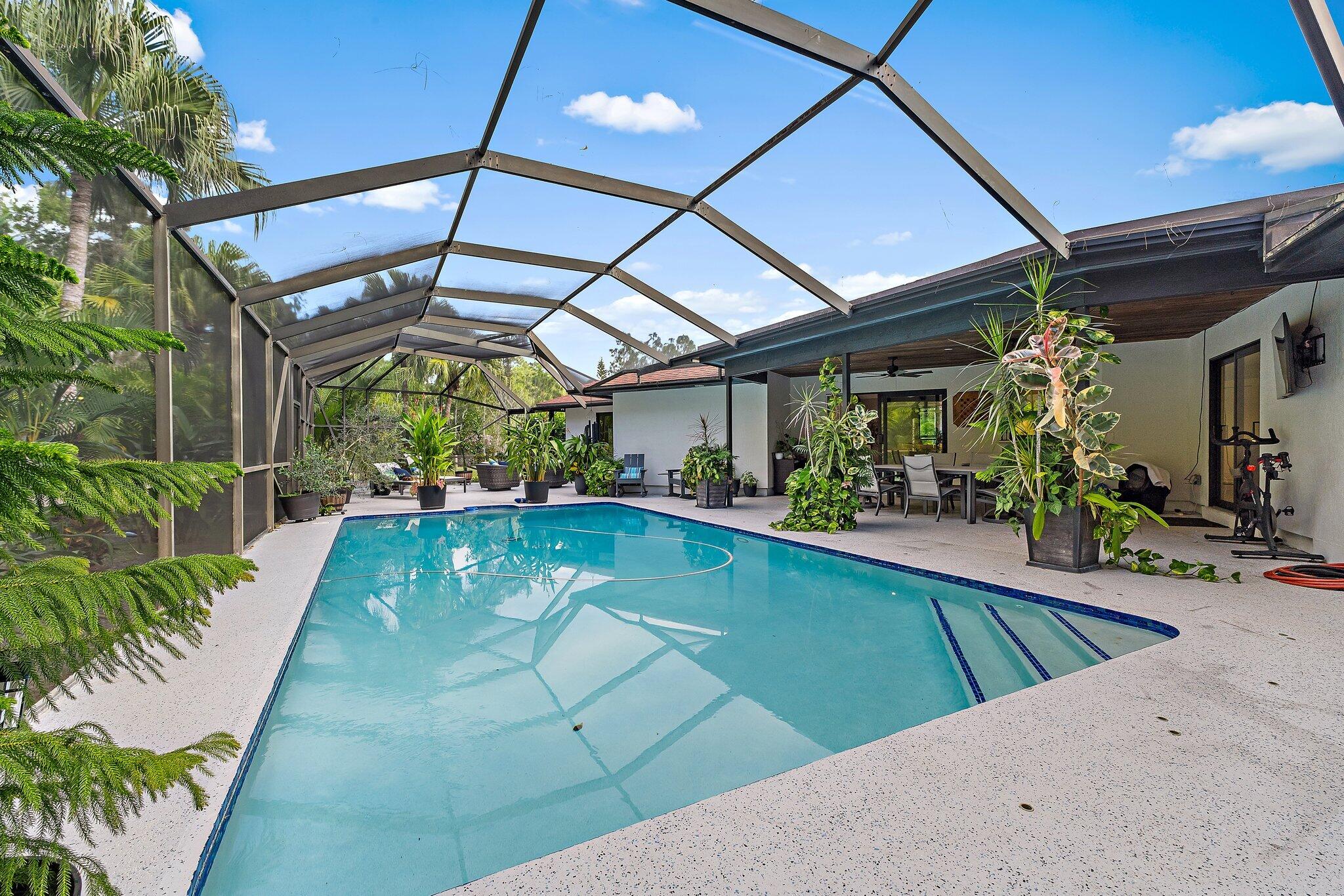 11845 165th Road North Jupiter, FL 33478 - Photo 56 of 68 a view of a backyard patio with swimming pool and table