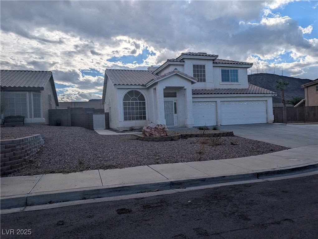104 Appian Way Henderson, NV 89002 - Photo 2 of 52 Mediterranean / spanish-style home featuring driveway, a garage, stucco siding, and a tiled roof