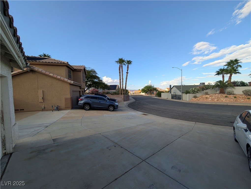 104 Appian Way Henderson, NV 89002 - Photo 22 of 52 View of concrete driveway featuring street lights and a residential view