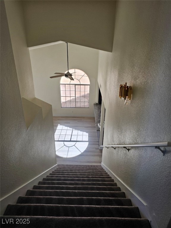 104 Appian Way Henderson, NV 89002 - Photo 50 of 52 Stairs featuring a textured wall, a high ceiling, and a ceiling fan