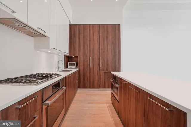 a living room with stainless steel appliances kitchen island furniture and a window