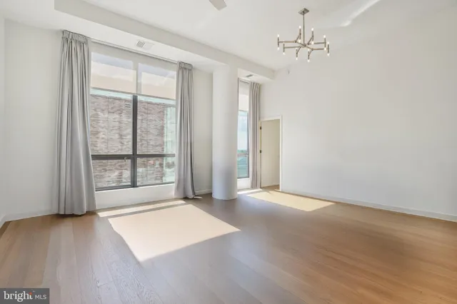 a living room with furniture kitchen view and a chandelier