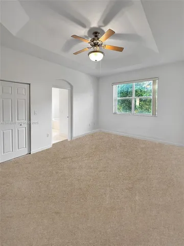 a view of a livingroom with a ceiling fan and window