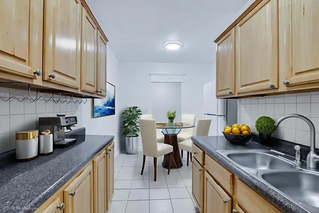 a kitchen with granite countertop a sink and a white wooden cabinets