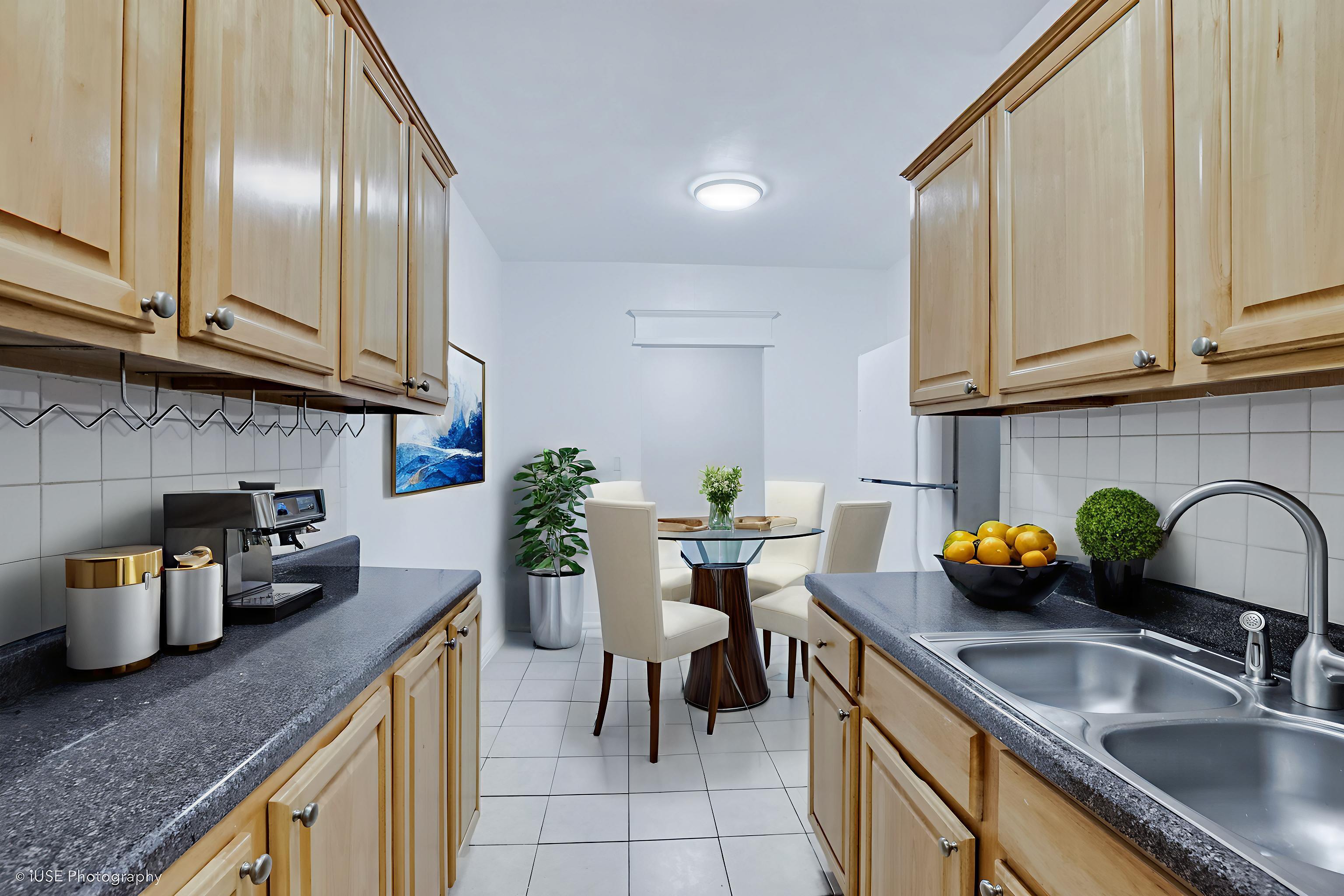1 West 126th Street, Unit 1C Manhattan, NY 10027 - Photo 1 of 11 a kitchen with granite countertop a sink and a white wooden cabinets