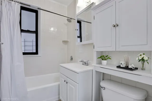 a bathroom with a sink toilet vanity and tub