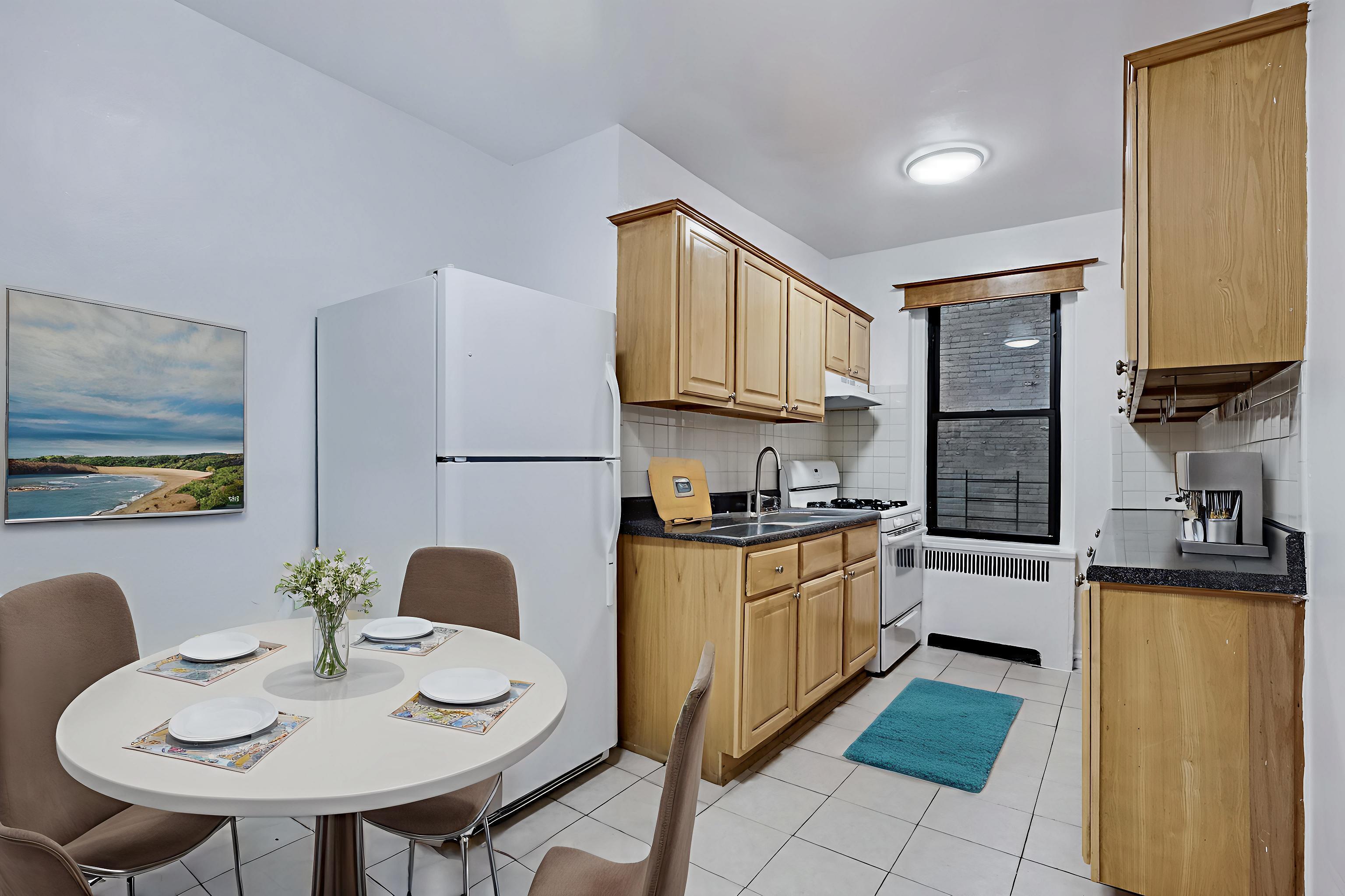 1 West 126th Street, Unit 1C Manhattan, NY 10027 - Photo 2 of 11 a kitchen with stainless steel appliances granite countertop a stove a sink a refrigerator a dining table and chairs