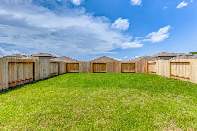 a view of backyard of house with green space