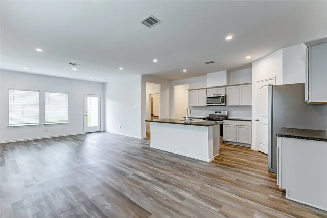 a kitchen with a refrigerator and a stove top oven