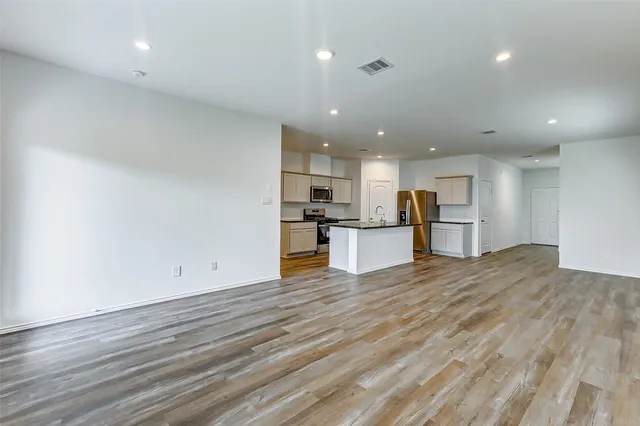 a view of kitchen dining space with a refrigerator wooden floor and a window