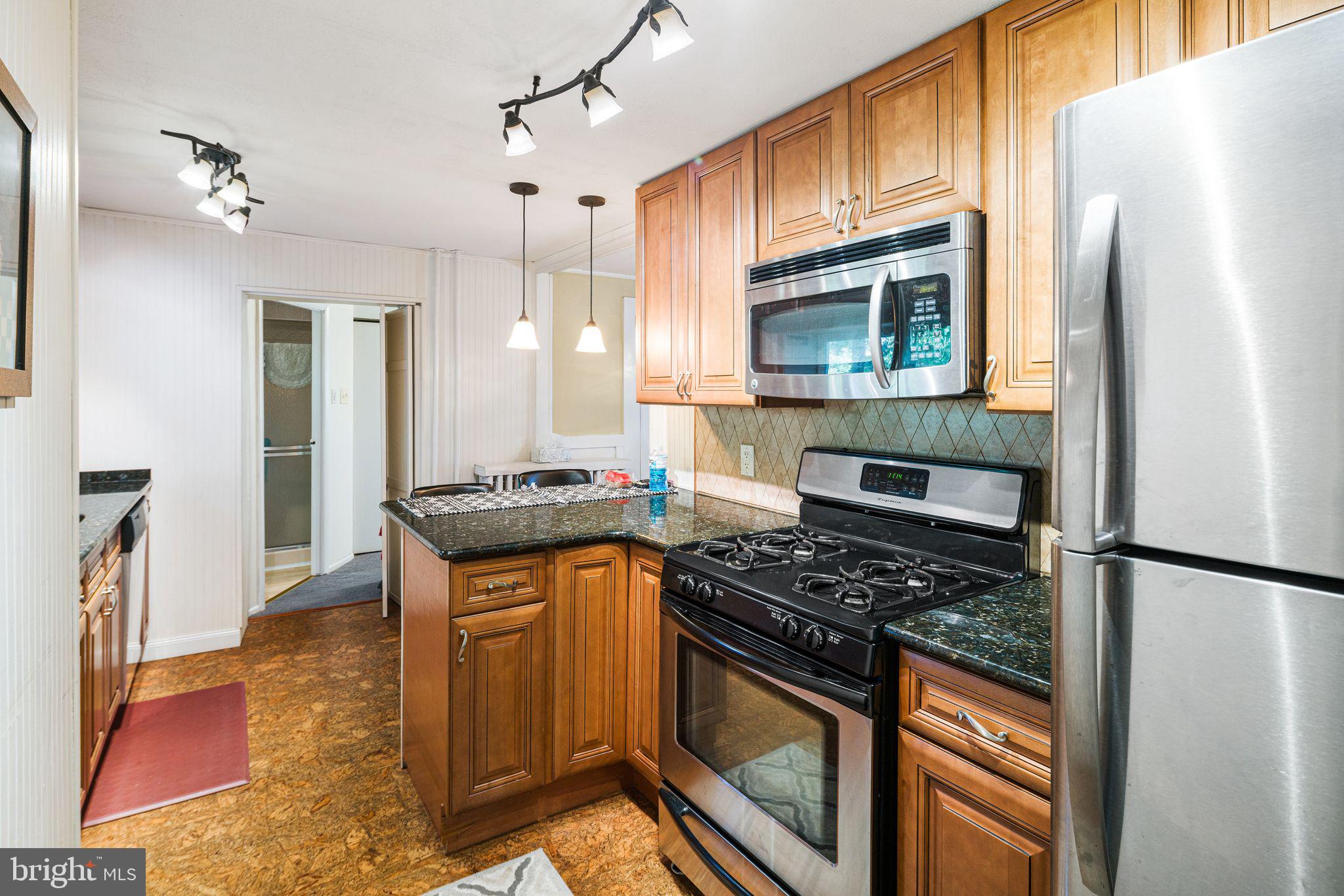 a kitchen with stainless steel appliances granite countertop a stove a sink and a refrigerator