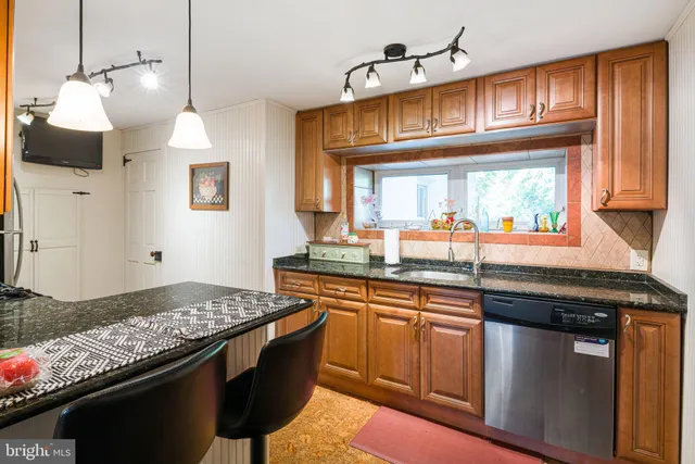 a kitchen with stainless steel appliances granite countertop a sink stove and cabinets