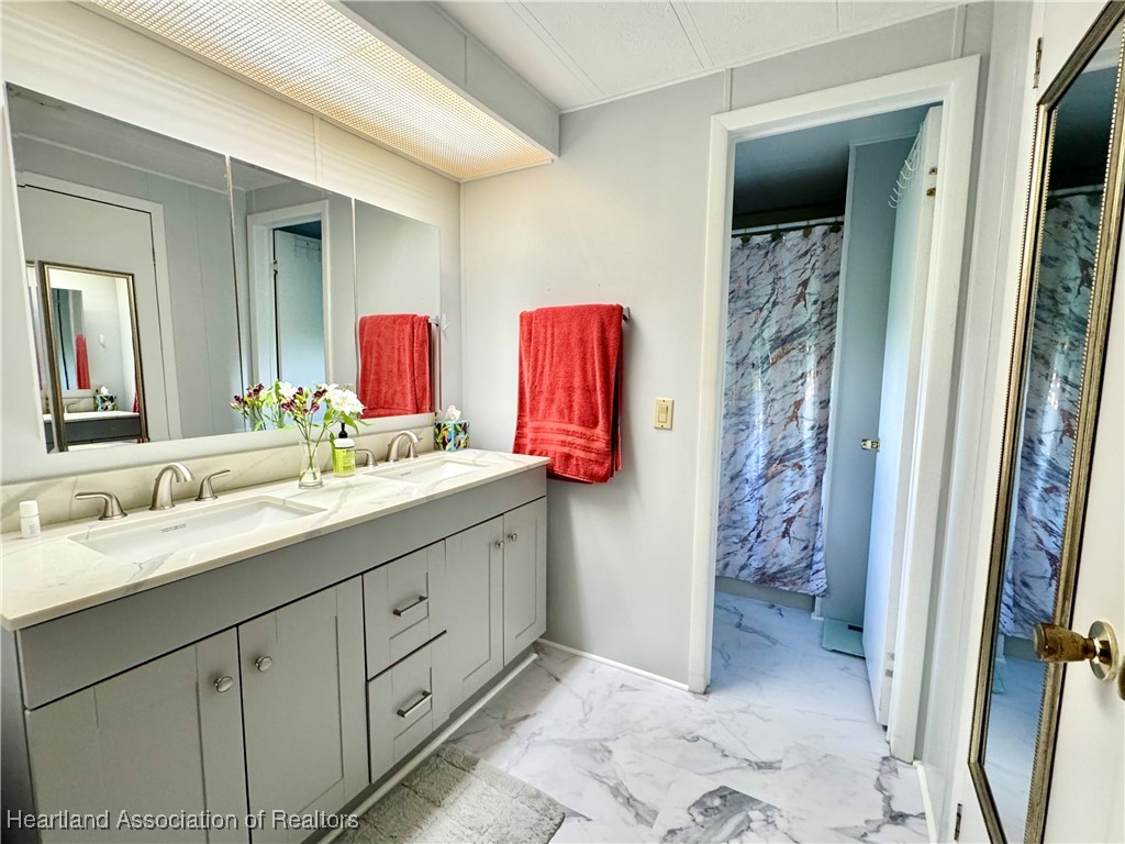 2940 Louis Street Sebring, FL 33872 - Photo 11 of 47 a bathroom with a double vanity sink mirror and shower