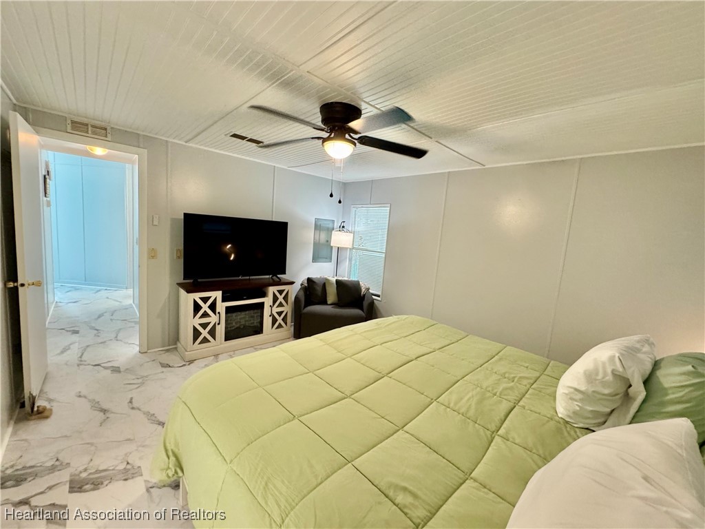 2940 Louis Street Sebring, FL 33872 - Photo 12 of 47 a bedroom with a bed and a flat screen tv