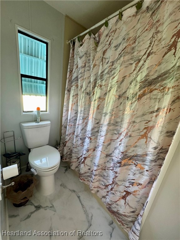 2940 Louis Street Sebring, FL 33872 - Photo 13 of 47 a white toilet sitting next to a shower curtain