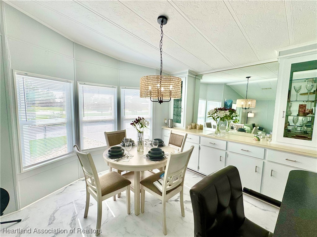 2940 Louis Street Sebring, FL 33872 - Photo 6 of 47 a dining room with furniture a chandelier and wooden floor
