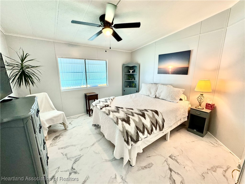2940 Louis Street Sebring, FL 33872 - Photo 8 of 47 a bedroom with a bed and a chandelier