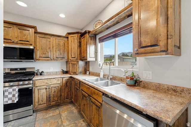 7776 Wagon Road East St. George, UT 84770 - Photo 15 of 76 Kitchen featuring stainless steel appliances, wood finish cabinetry, dark stone finish floors, light countertops, and recessed lighting