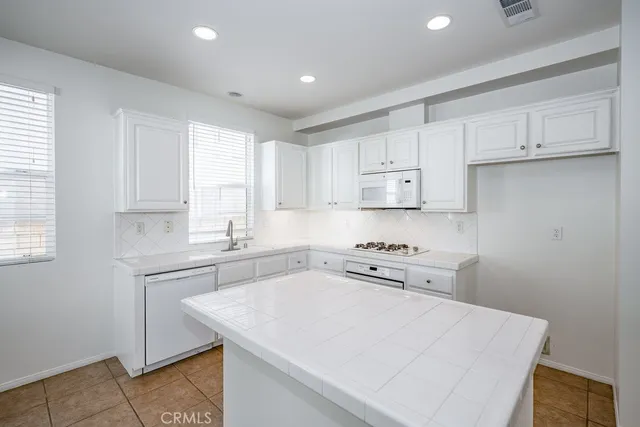 a kitchen with a sink a stove and cabinets