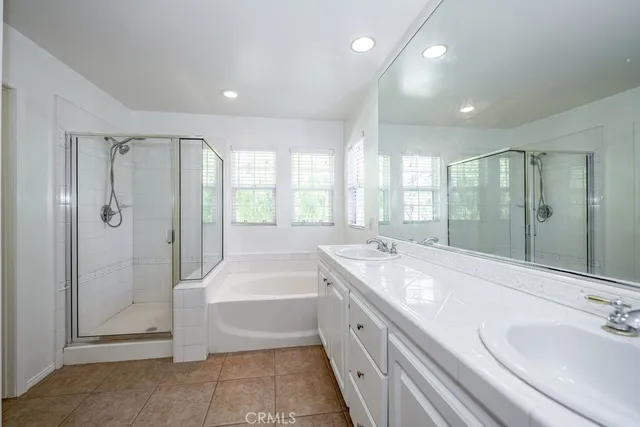 a spacious bathroom with a tub sink shower and mirror