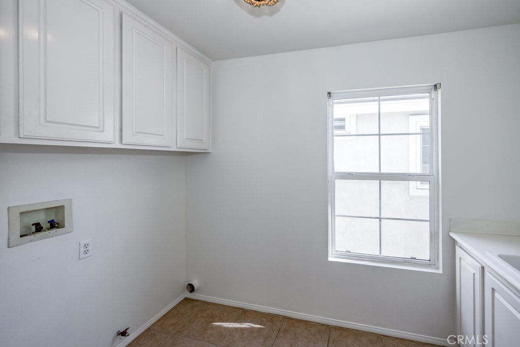 23321 Beachcomber Lane Valencia, CA 91355 - Photo 23 of 40 Laundry room or utility room space — washer/dryer area with window in Valencia home.