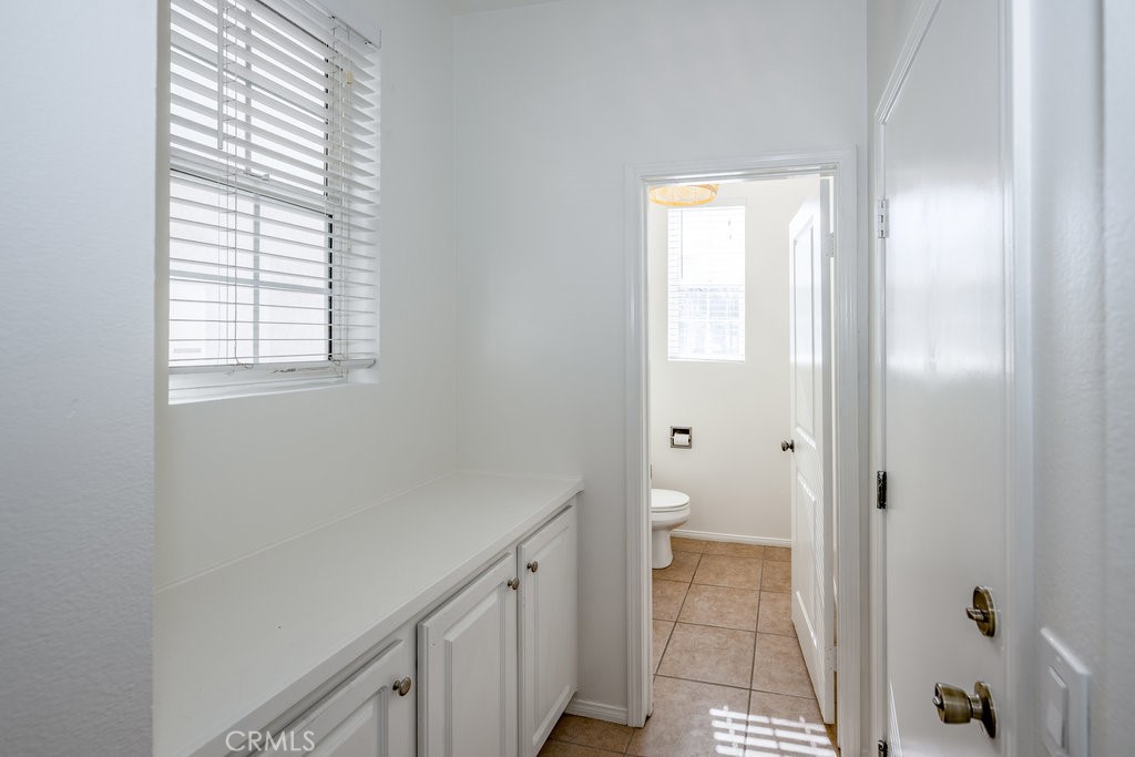 23321 Beachcomber Lane Valencia, CA 91355 - Photo 8 of 40 “Half-bath right off the garage entry — a convenient guest powder room with tile floor and clean neutral walls, perfect for quick access from the driveway or mud-zone.”